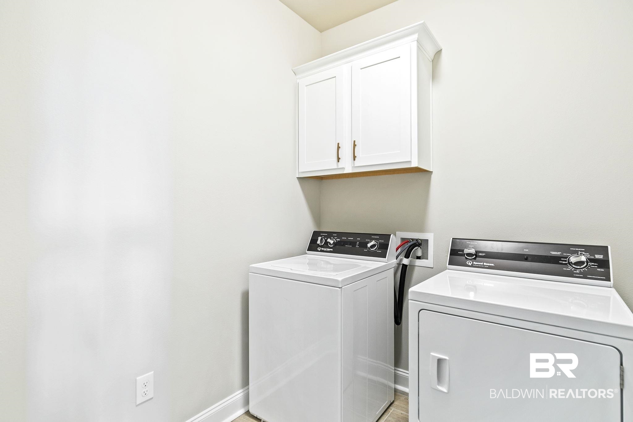 10140 Chipper Lane Foley, AL 36535 - Photo 24 of 72 Laundry area with light wood-type flooring, washing machine and dryer, and cabinets