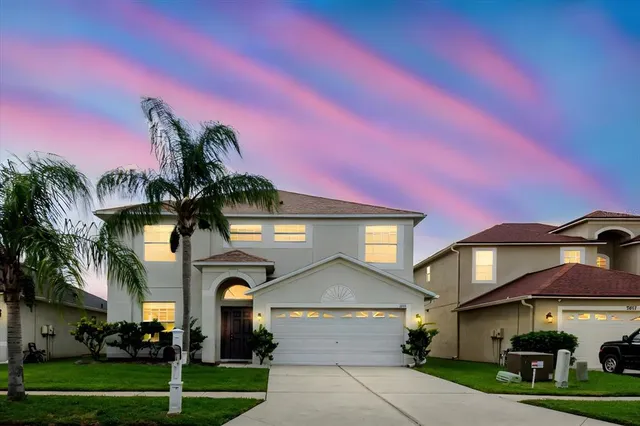 a front view of a house with a yard and potted plants