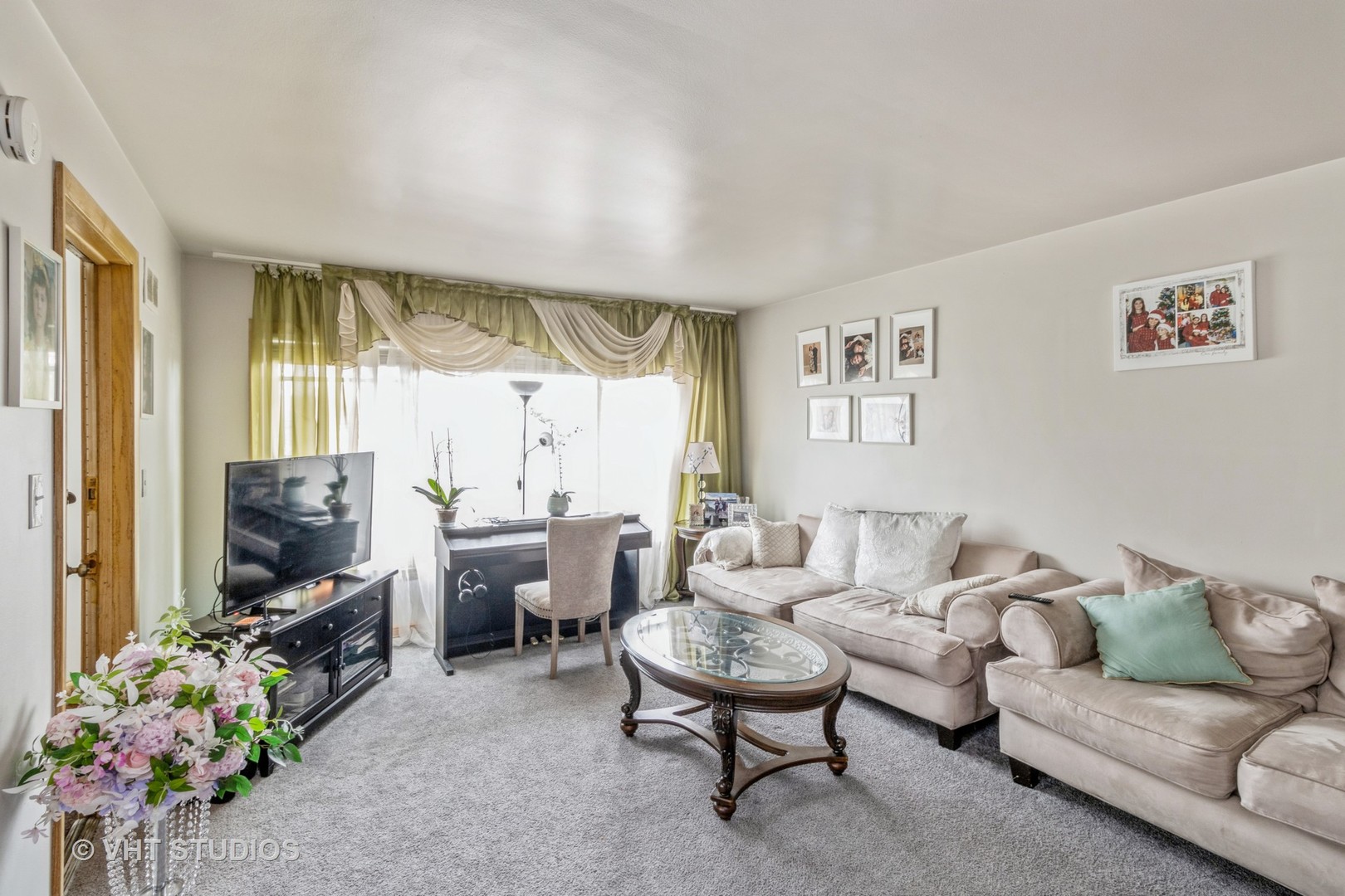 8517 West Foster Avenue Chicago, IL 60656 - Photo 2 of 21 a living room with furniture a flat screen tv and a floor to ceiling window