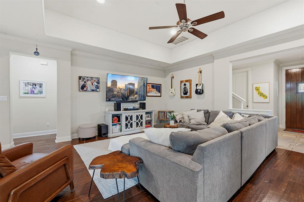 15317 Falconhead Grove Loop Austin, TX 78738 - Photo 7 of 29 Rich hardwood floors complement this inviting living space, crowned by a tray ceiling and a central ceiling fan.