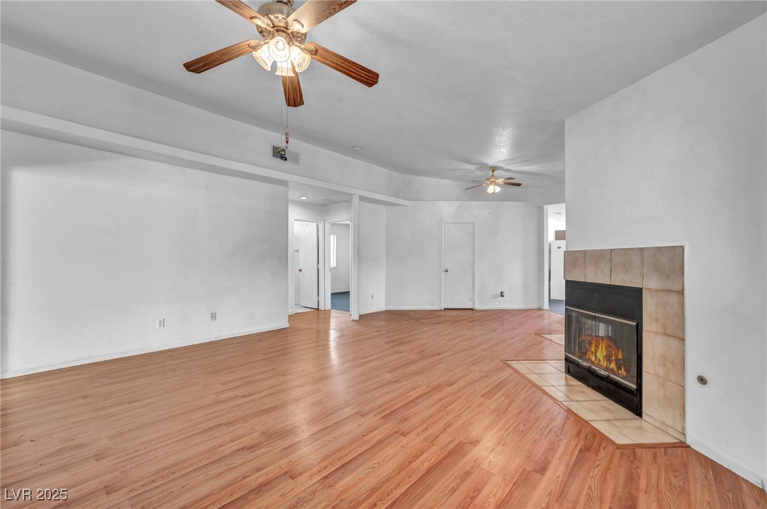 2165 St Paul Way Las Vegas, NV 89104 - Photo 11 of 45 Unfurnished living room with ceiling fan, light wood-style floors, and a fireplace