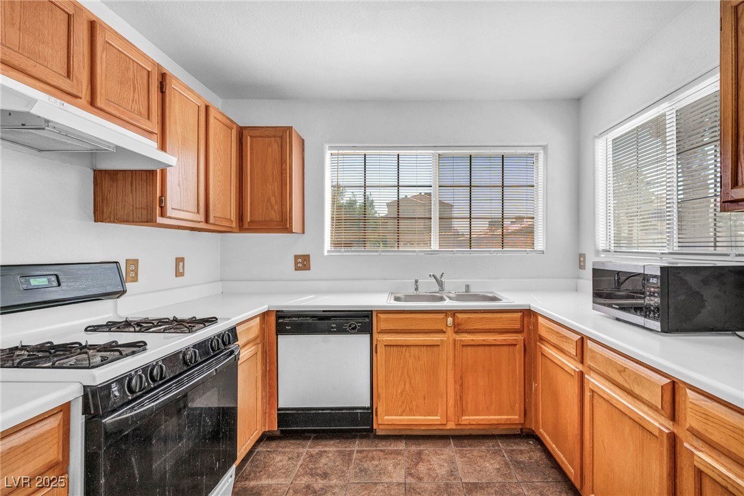 2165 St Paul Way Las Vegas, NV 89104 - Photo 16 of 45 Kitchen featuring white appliances, under cabinet range hood, and light countertops