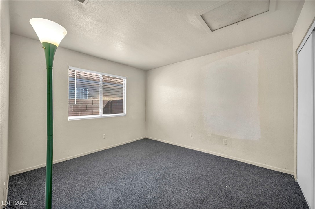 2165 St Paul Way Las Vegas, NV 89104 - Photo 20 of 45 Empty room featuring attic access, dark carpet, and a textured ceiling
