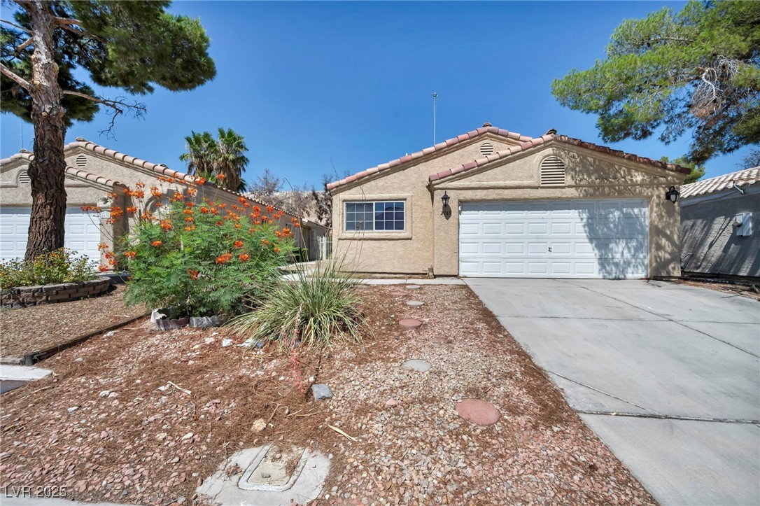 2165 St Paul Way Las Vegas, NV 89104 - Photo 2 of 45 Ranch-style home with stucco siding, driveway, a tile roof, and an attached garage
