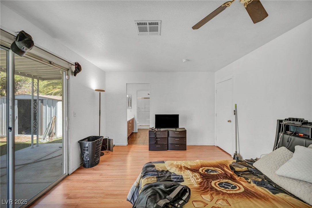 2165 St Paul Way Las Vegas, NV 89104 - Photo 29 of 45 Bedroom featuring access to outside, wood finished floors, connected bathroom, and a ceiling fan