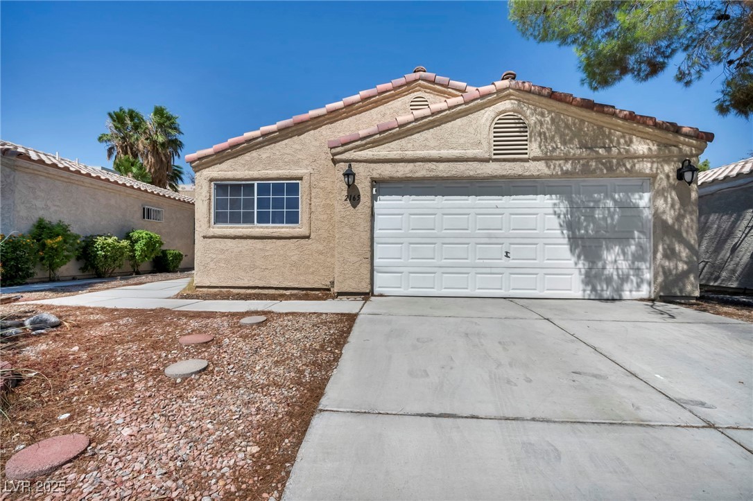 2165 St Paul Way Las Vegas, NV 89104 - Photo 3 of 45 Mediterranean / spanish-style home with stucco siding, concrete driveway, a tiled roof, and a garage
