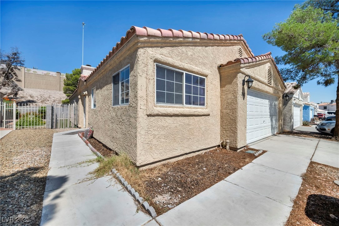 2165 St Paul Way Las Vegas, NV 89104 - Photo 4 of 45 View of property exterior with stucco siding, a garage, driveway, and a tile roof