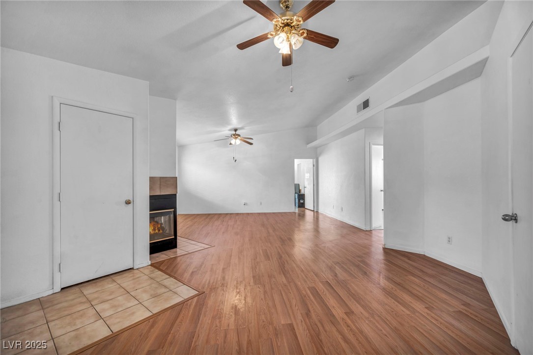 2165 St Paul Way Las Vegas, NV 89104 - Photo 5 of 45 Unfurnished living room with ceiling fan, a tile fireplace, and wood finished floors