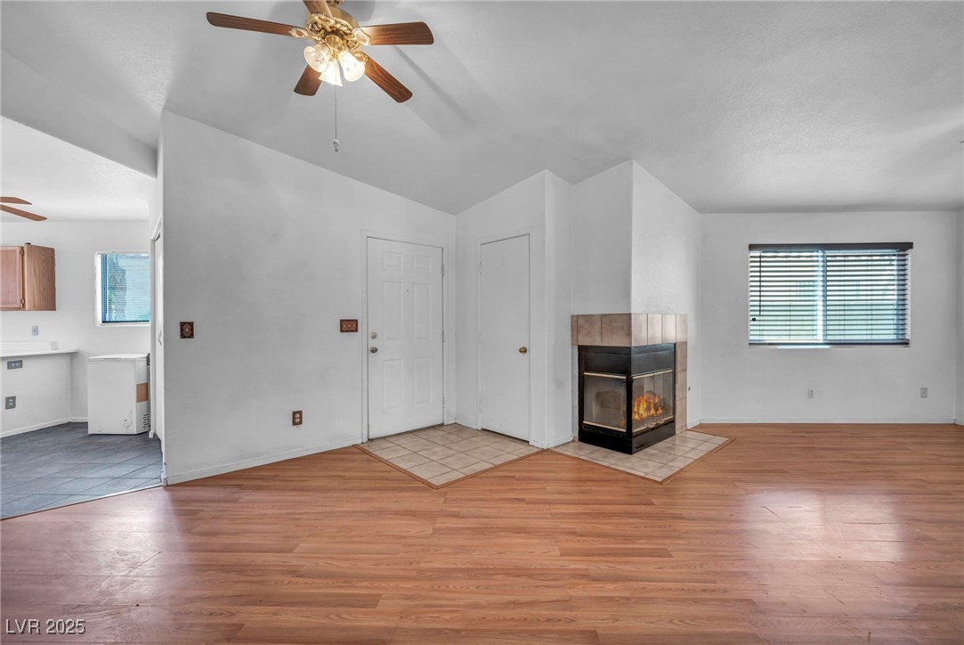 2165 St Paul Way Las Vegas, NV 89104 - Photo 10 of 45 Unfurnished living room featuring a ceiling fan, light wood finished floors, lofted ceiling, and a fireplace