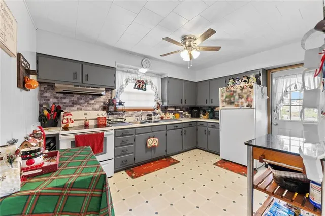 a kitchen with a refrigerator and a wooden floor