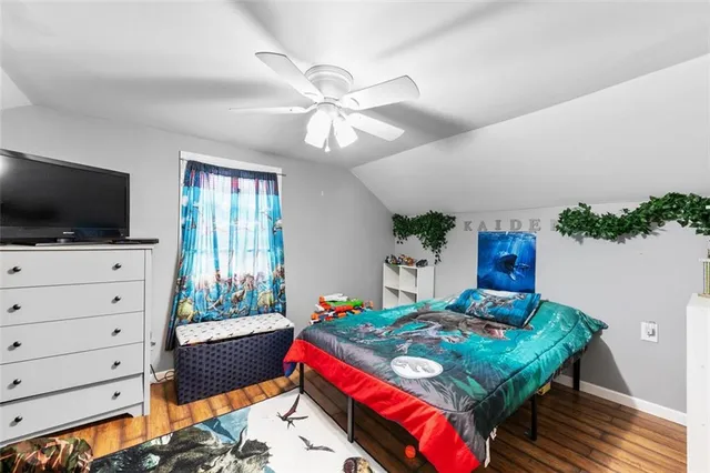 a bedroom with a bed a flat screen tv and a dresser