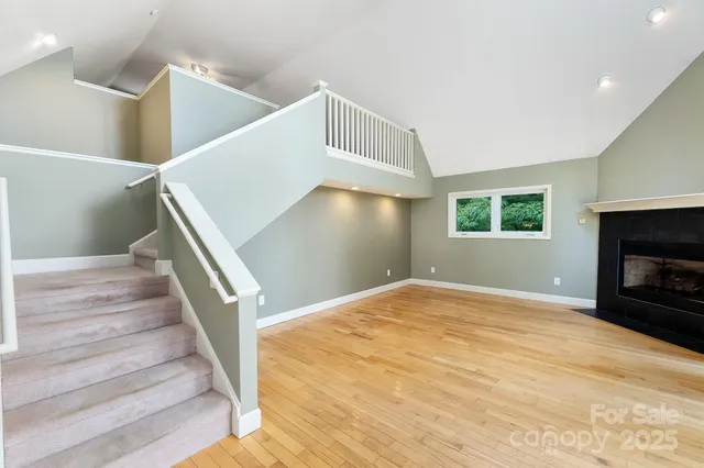 a view of empty room with wooden floor and fireplace