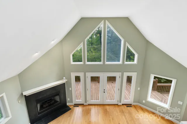 an empty room with windows and chandelier fan
