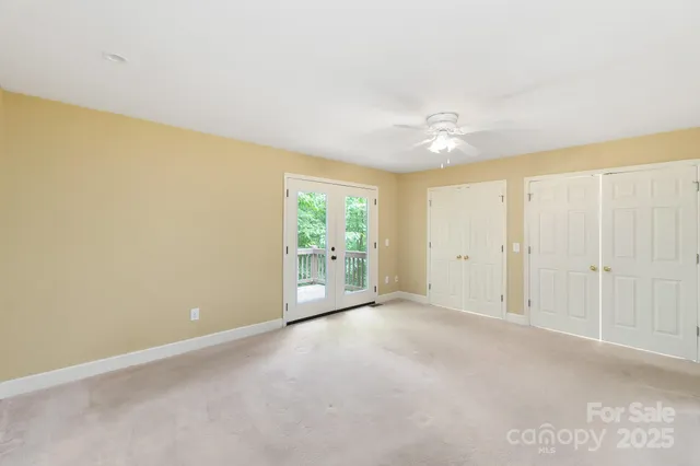 a view of a livingroom with a chandelier fan and windows