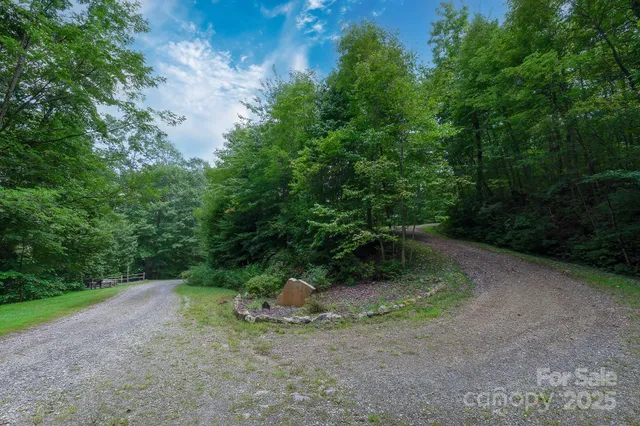 a sign board with flower plants and wooden fence