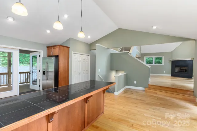 a large kitchen with stainless steel appliances a large counter top a refrigerator and a sink