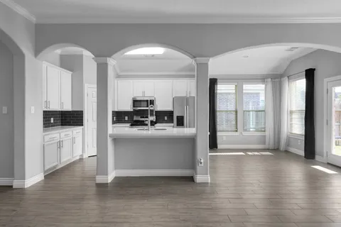 a view of kitchen with sink and refrigerator