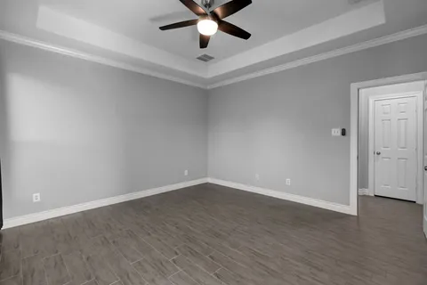 a view of an empty room with wooden floor