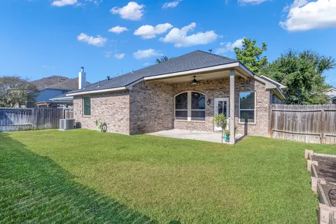 a backyard of a house with table and chairs