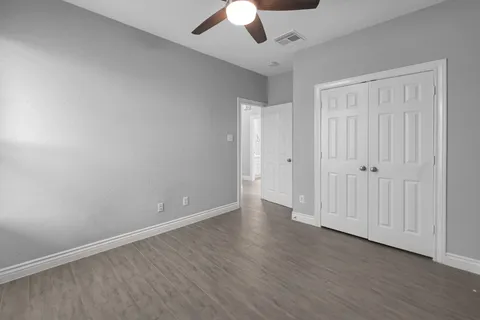 a view of an empty room with wooden floor