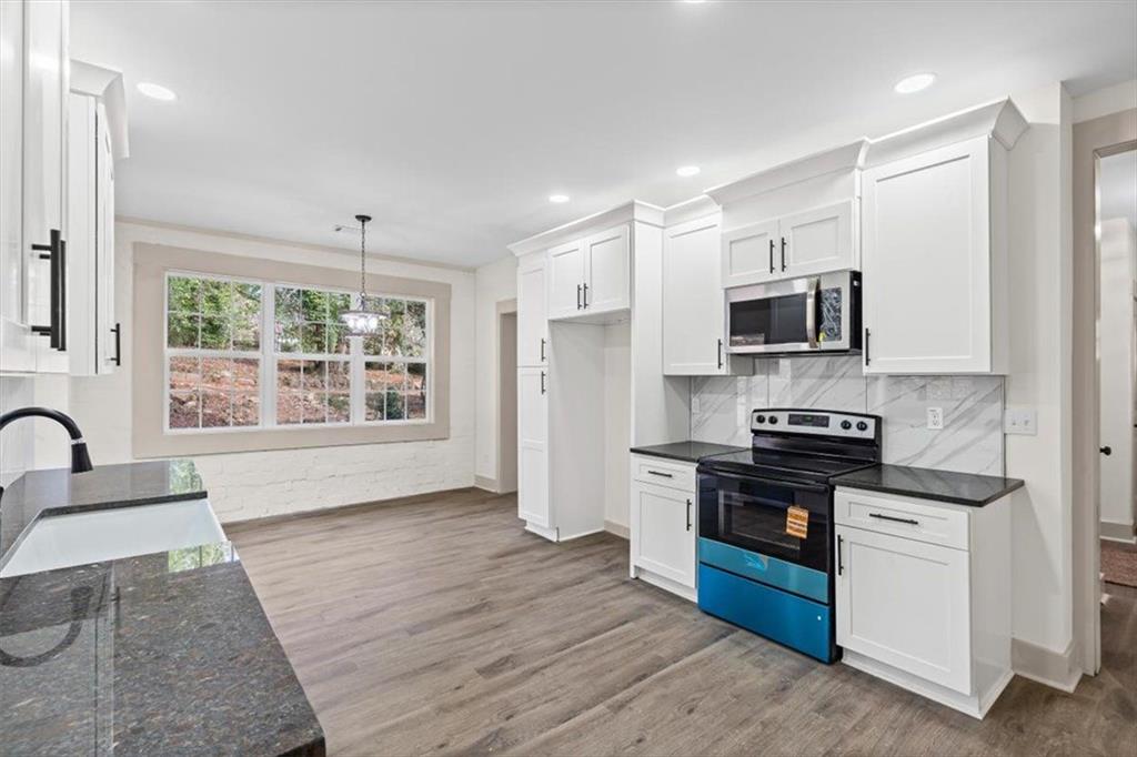 203 Church Street Northeast Rome, GA 30161 - Photo 12 of 36 a kitchen with stainless steel appliances kitchen island granite countertop a stove a sink and a refrigerator