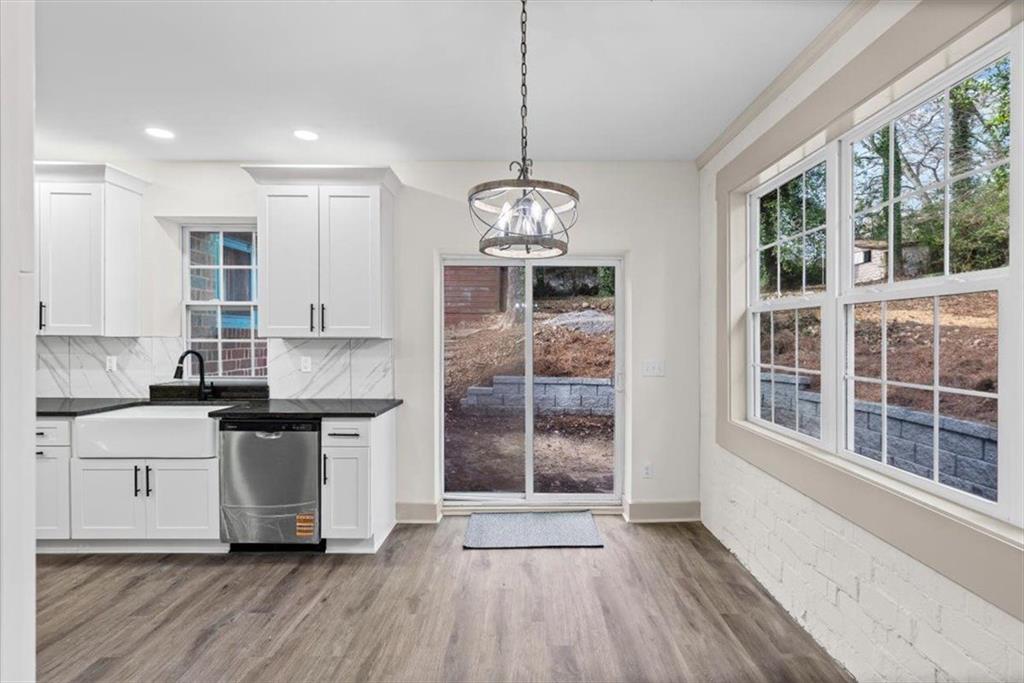 203 Church Street Northeast Rome, GA 30161 - Photo 15 of 36 a kitchen with stainless steel appliances granite countertop a stove and white cabinets with wooden floor