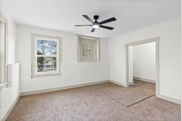 a front view of a house with a yard and large tree