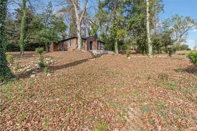 a large kitchen with stainless steel appliances granite countertop a stove a sink and white cabinets with wooden floor next to windows
