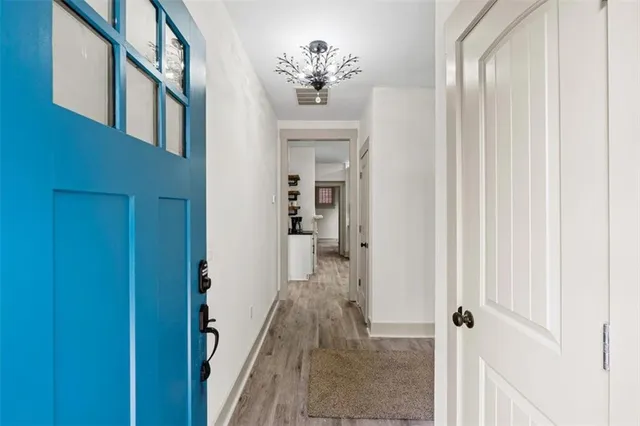 a kitchen with stainless steel appliances granite countertop a stove and white cabinets with wooden floor