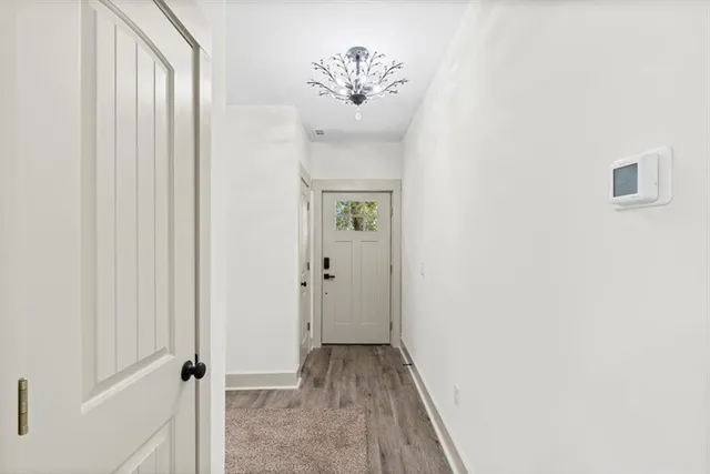 a view of a kitchen with refrigerator and wooden floor