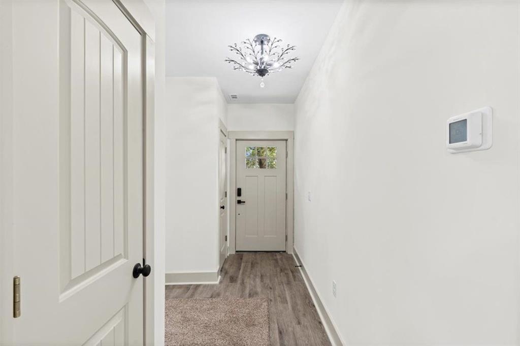 203 Church Street Northeast Rome, GA 30161 - Photo 8 of 36 a view of a hallway with wooden floor and a chandelier