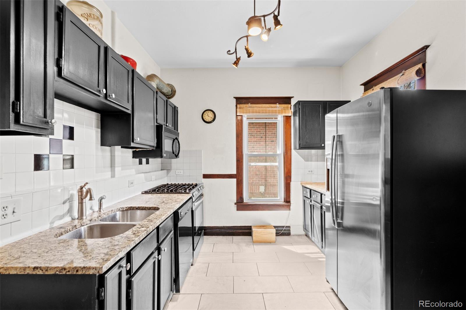 3517 York Street Denver, CO 80205 - Photo 14 of 45 a kitchen with stainless steel appliances granite countertop a sink stove and refrigerator