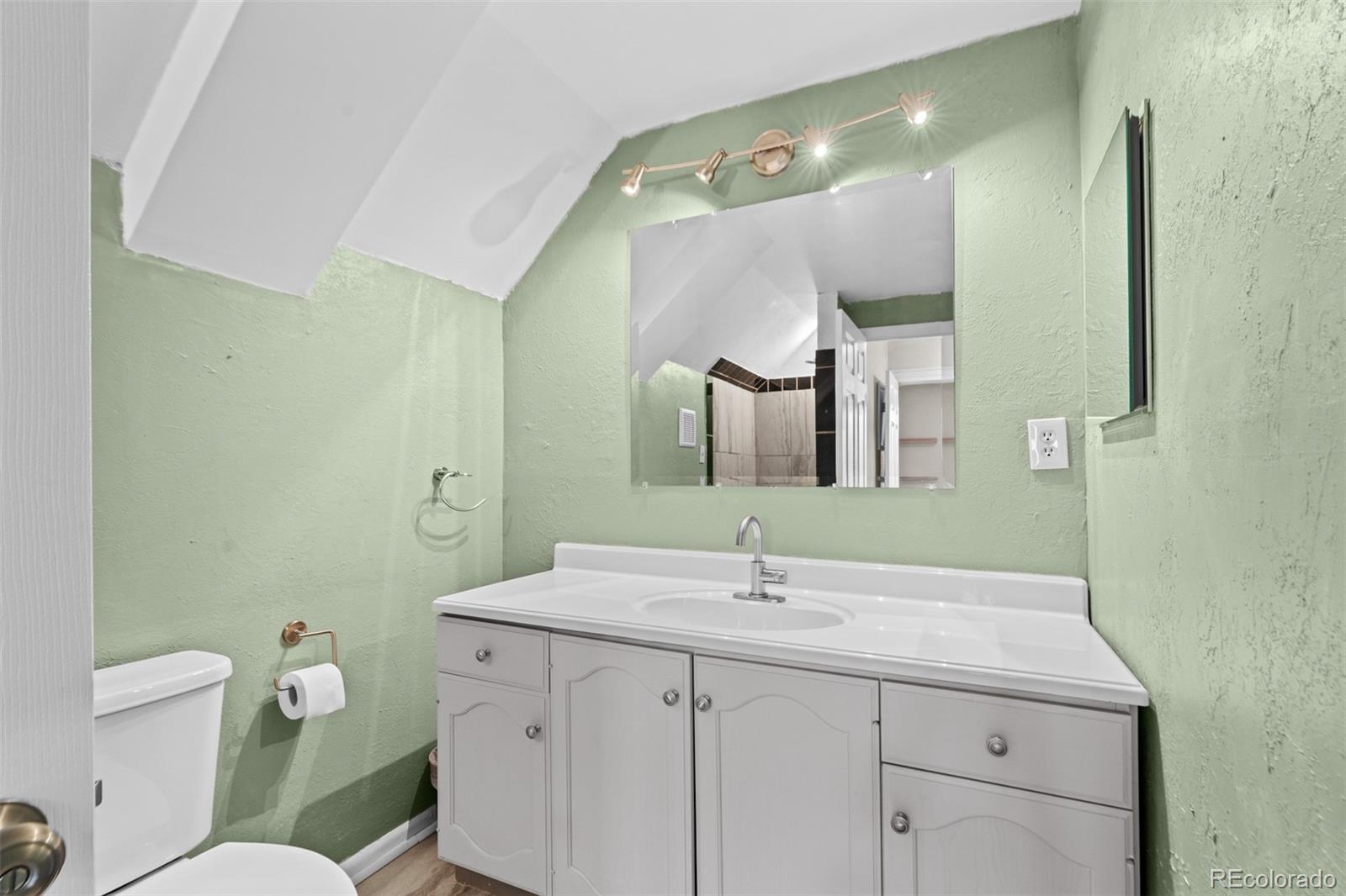 3517 York Street Denver, CO 80205 - Photo 28 of 45 a bathroom with a toilet sink and mirror