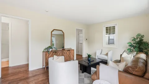 a living room with furniture flowerpot and wooden floor