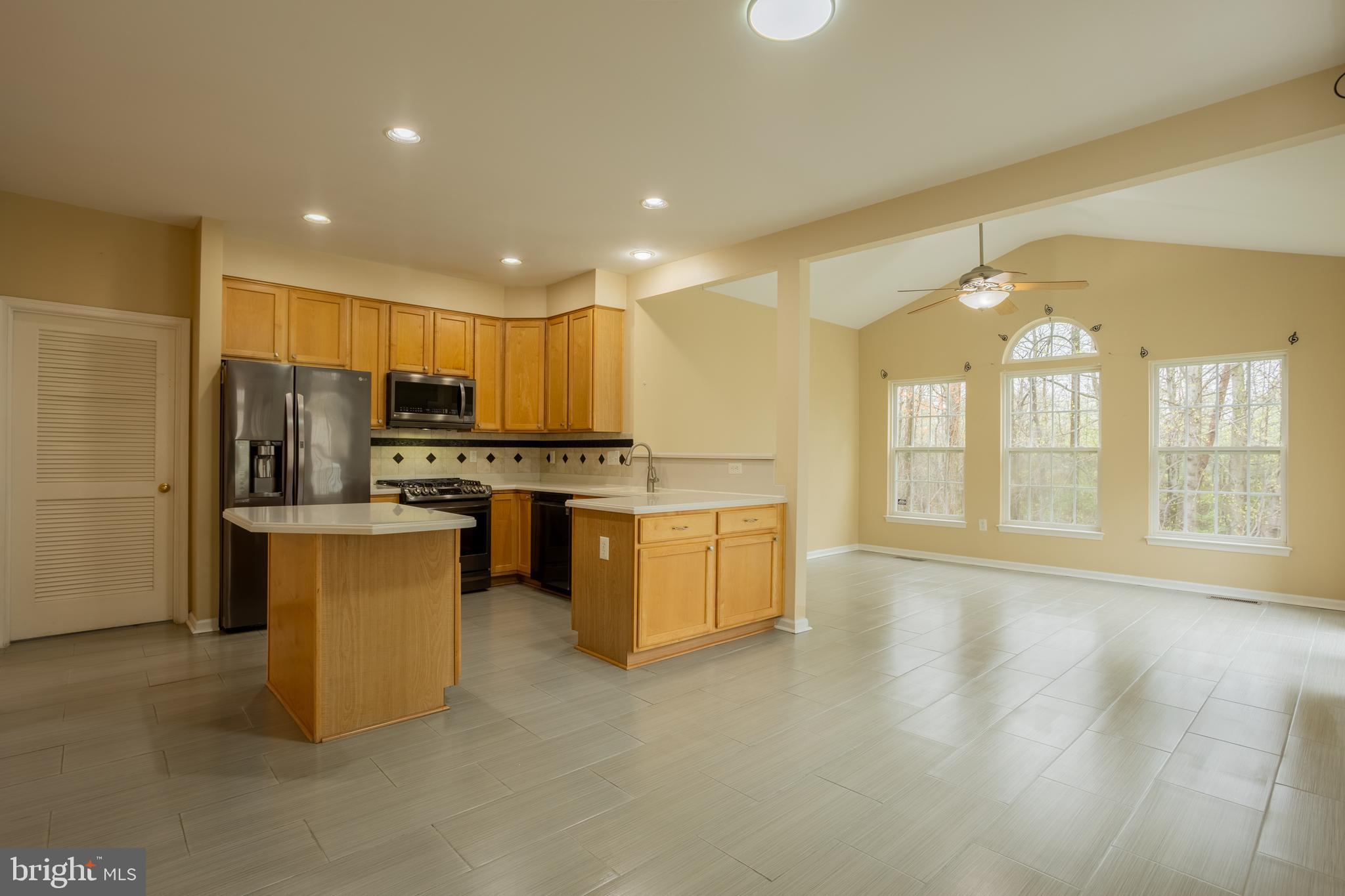 7740 Rotherham Drive Hanover, MD 21076 - Photo 12 of 62 a large kitchen with stainless steel appliances kitchen island granite countertop a stove and a large window