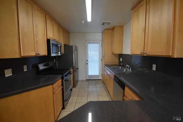 a kitchen with stainless steel appliances granite countertop a stove a sink and a microwave