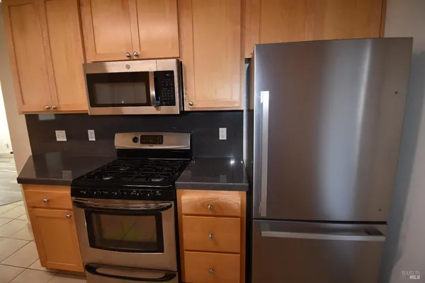 a kitchen with stainless steel appliances granite countertop a refrigerator stove and microwave