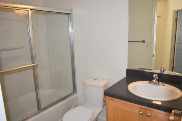 a bathroom with a granite countertop sink toilet and shower