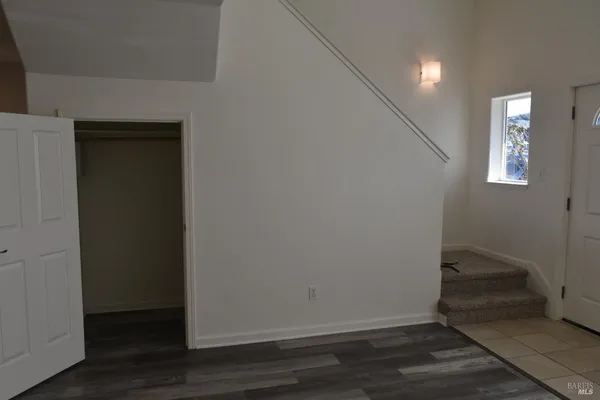 an empty room with wooden floor and closet