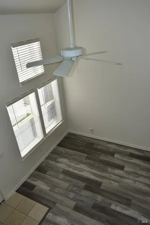 a view of an empty room with closet and a window