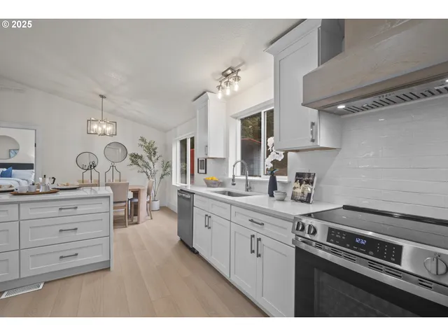 a kitchen with cabinets stainless steel appliances and a window