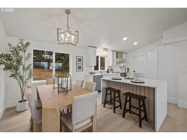 a dining area with a table chairs and a kitchen view