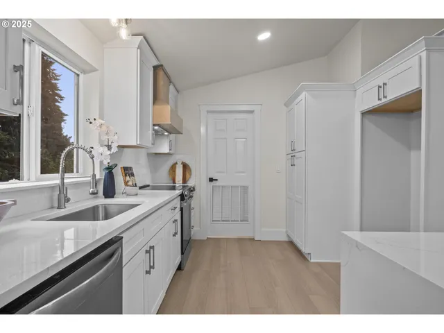 a kitchen with a sink cabinets and a window