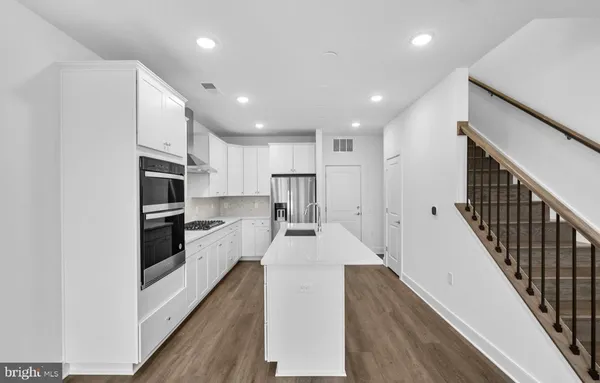a kitchen with granite countertop a large counter top appliances and cabinets