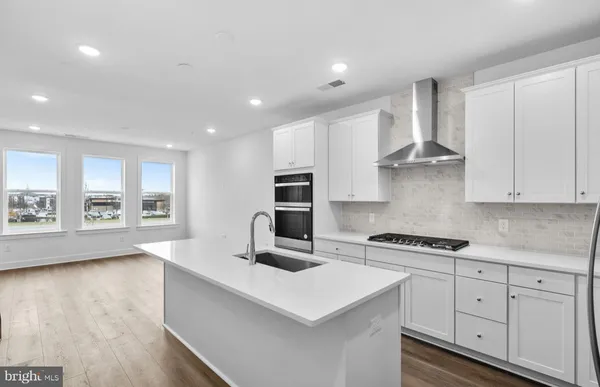 a kitchen with sink stove and cabinets