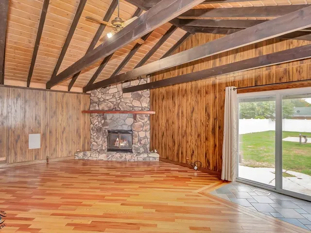 a view of an empty room with a fireplace and a chandelier