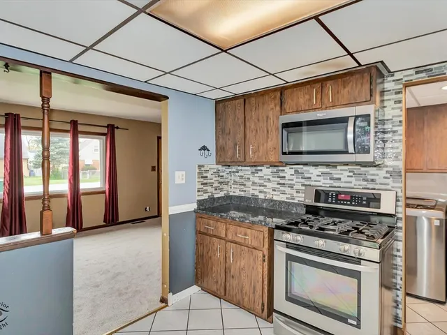 a kitchen with stainless steel appliances granite countertop a stove and a microwave