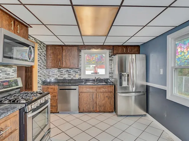 a kitchen with stainless steel appliances granite countertop a stove a refrigerator and a sink