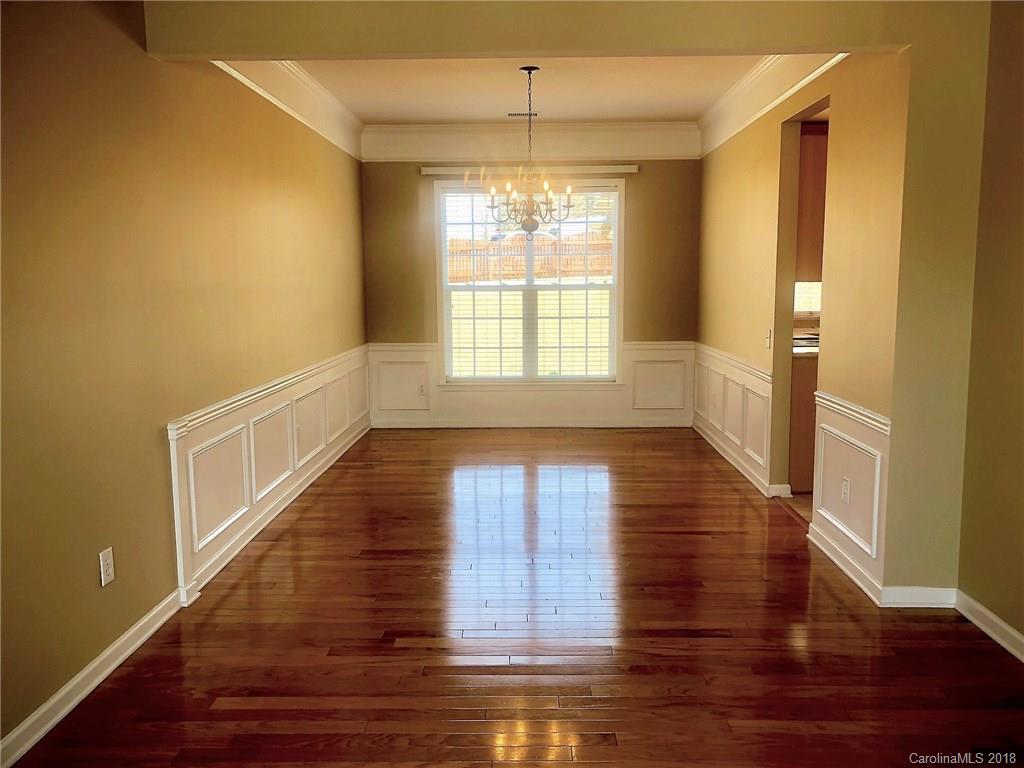2401 Coltsgate Road Waxhaw, NC 28173 - Photo 4 of 22 a view of an empty room with wooden floor and a window