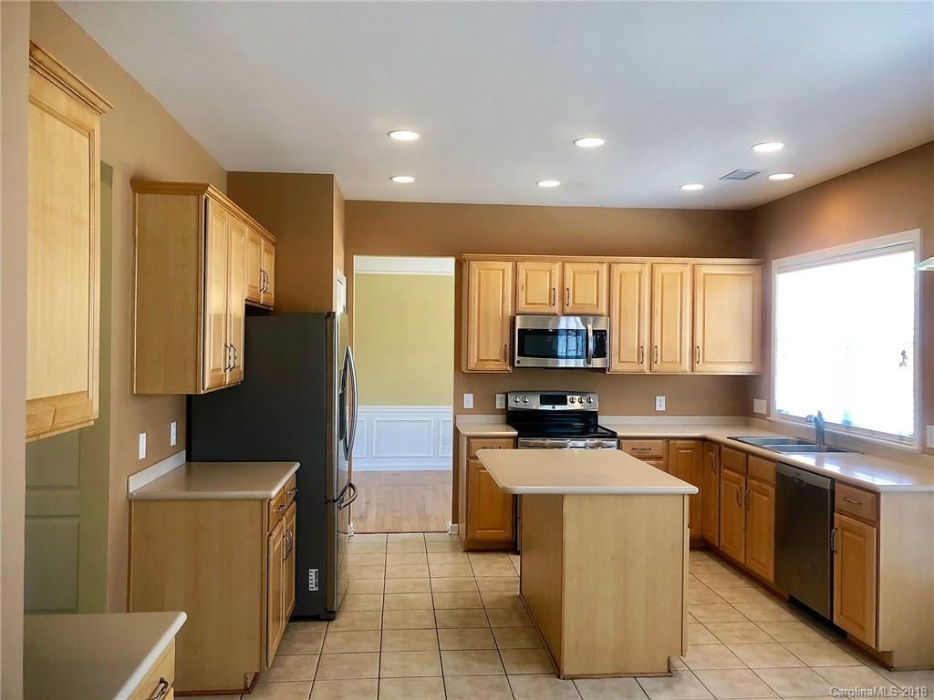 2401 Coltsgate Road Waxhaw, NC 28173 - Photo 6 of 22 a kitchen with a sink a counter top space stainless steel appliances and cabinets